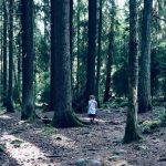 Little girl with white dress in the forest enjoying the seasonal living.