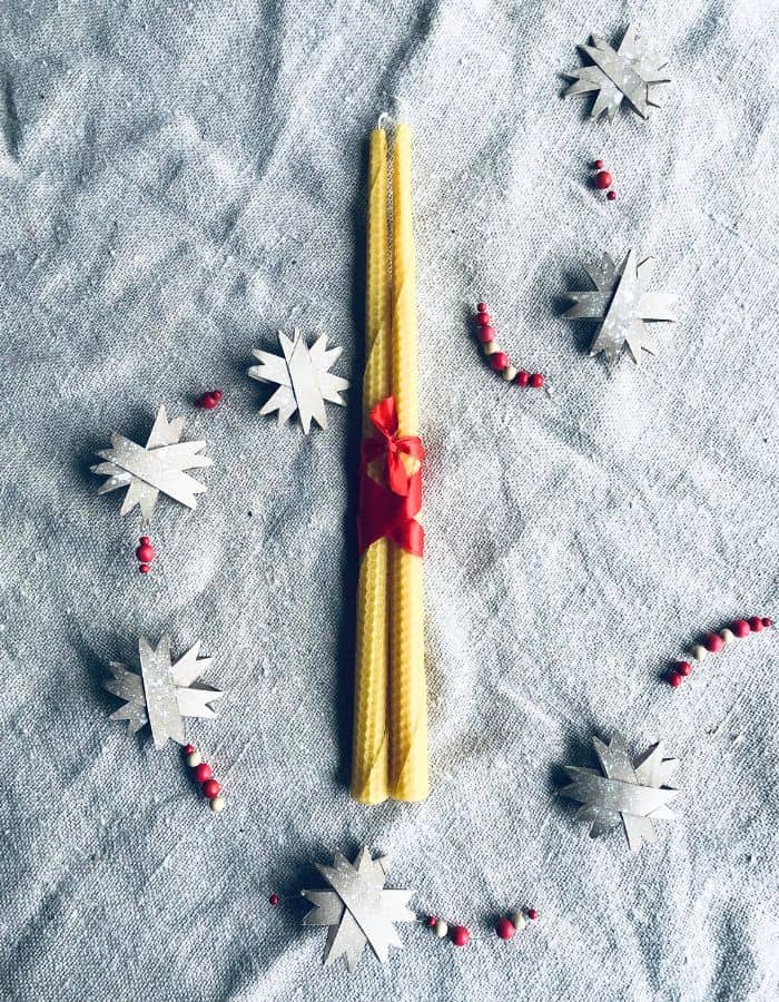A natural gift package with two beeswax candles tied together with a ribbon.