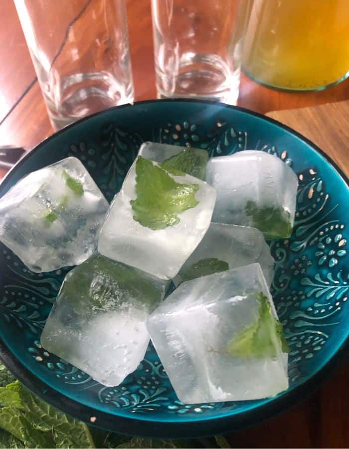 Mint ice cubes in a blue bowl ready for the iced mint tea.