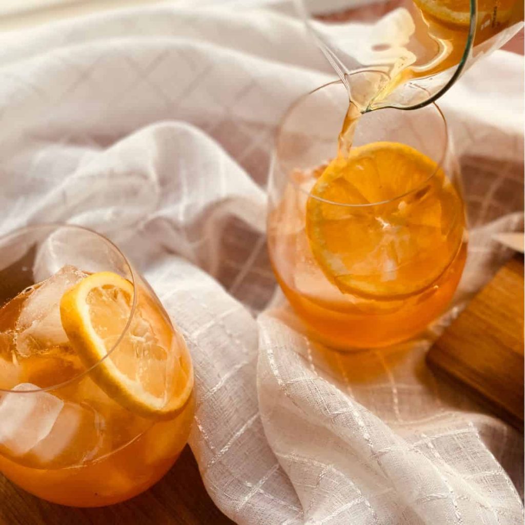 Iced rooibos tea in glasses with lemon juice and honey.