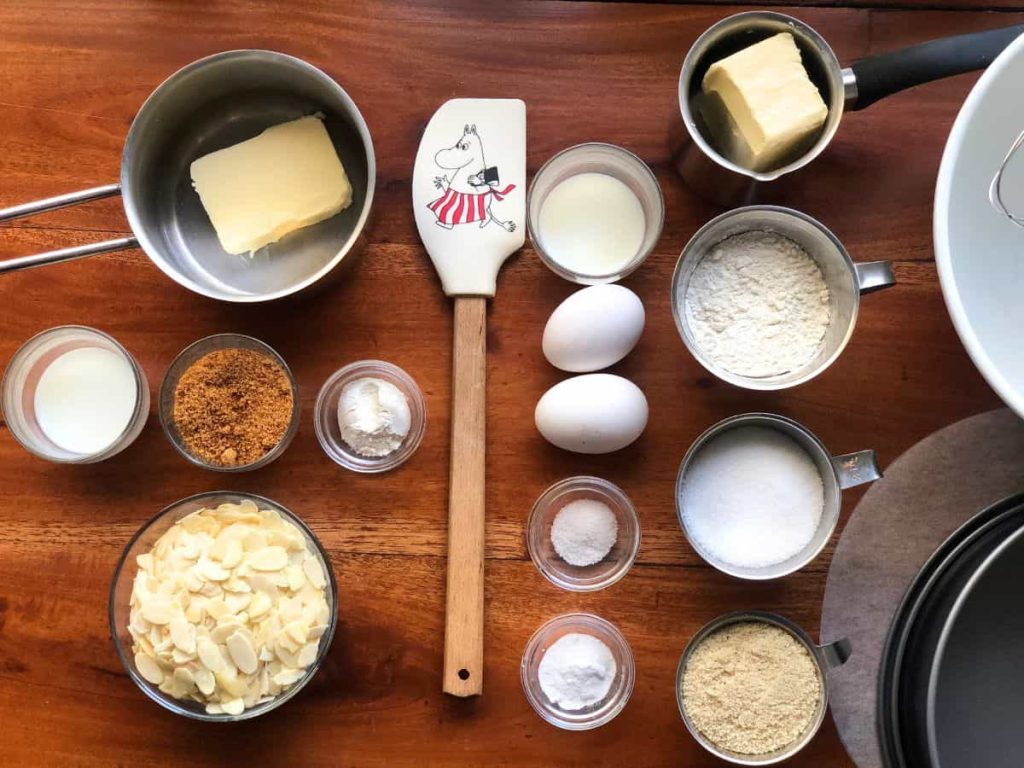Tosca cake ingredients flatlay. On the left side the caramelized almond topping ingredients and right side the cake batter ingredients.