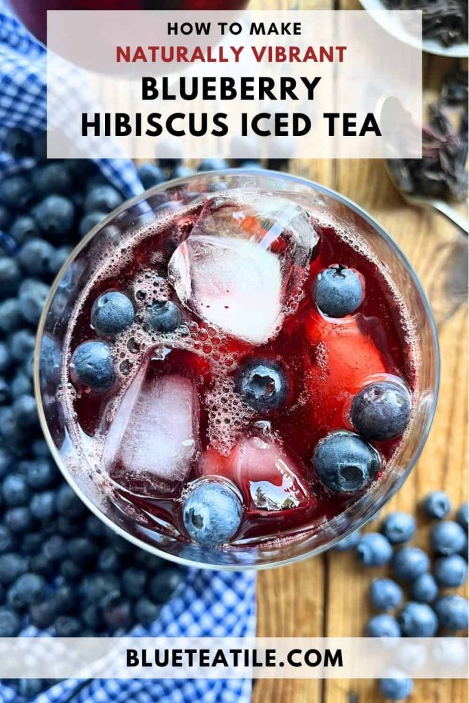 A glass of vibrant colored blueberry iced tea with hibiscus in the glass with ice cubes and blueberries.