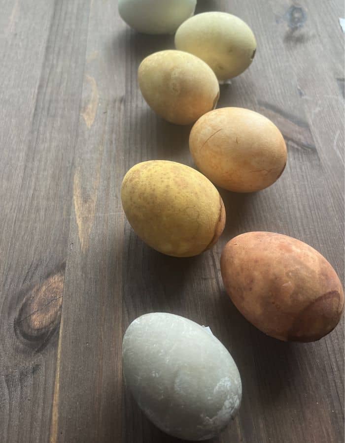 Naturally tea colored easter eggs against a dark wooden surface.