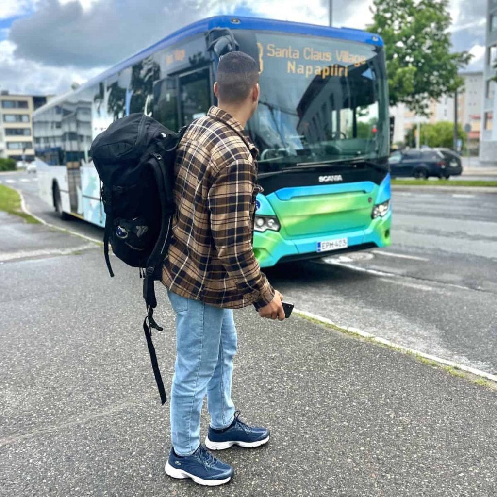 A boy with a backpack waiting a bus to arrive