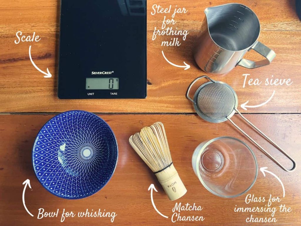 Tools for making vanilla matcha latte: scale, bowl, steel jar, tea sieve, matcha chasen, glass for soaking the chasen.