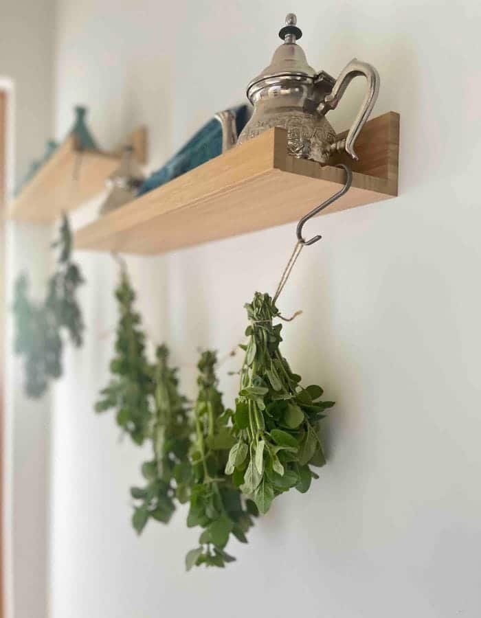 Drying herbs for tea on a string attached to the hooks under the shelf.